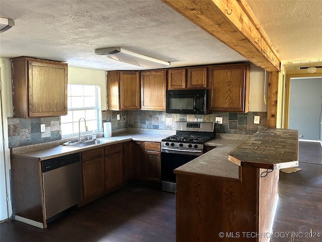 kitchen featuring a breakfast bar, sink, decorative backsplash, kitchen peninsula, and stainless steel appliances