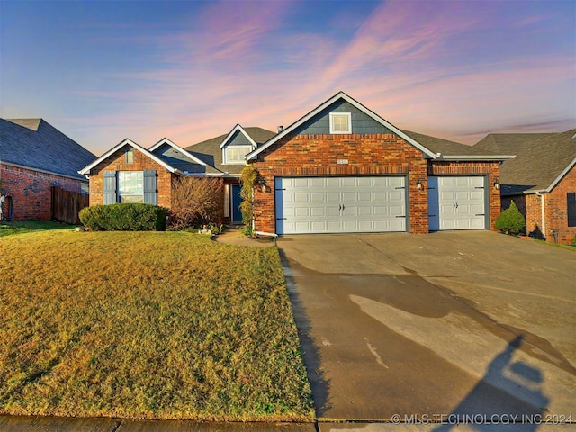 view of front of home with a yard and a garage