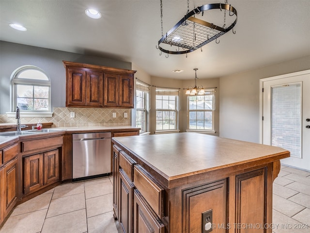 kitchen featuring pendant lighting, stainless steel dishwasher, plenty of natural light, and a kitchen island