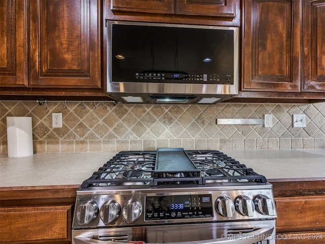 kitchen with tasteful backsplash and appliances with stainless steel finishes