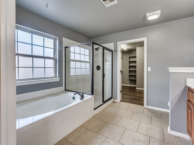 bathroom with tile patterned floors, vanity, and plus walk in shower