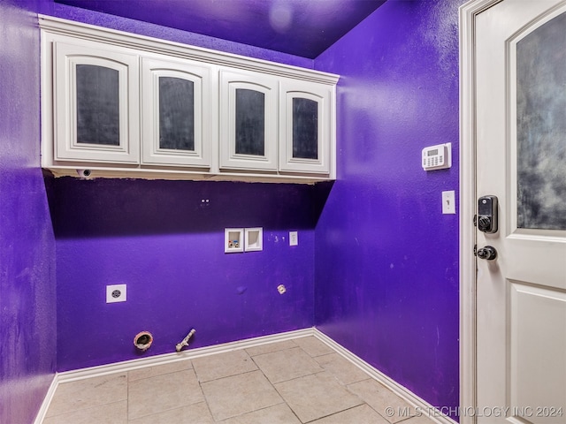 washroom with hookup for an electric dryer, washer hookup, cabinets, gas dryer hookup, and light tile patterned floors