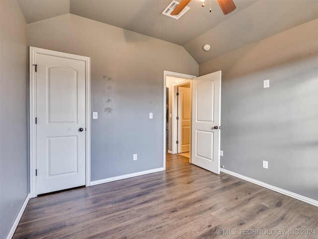 unfurnished bedroom with ceiling fan, lofted ceiling, and dark wood-type flooring