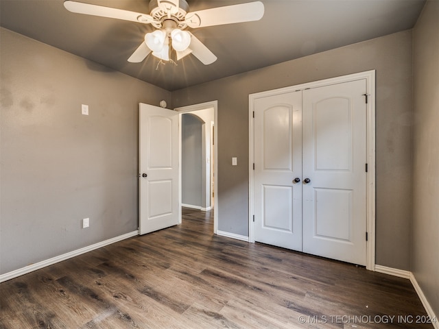 unfurnished bedroom featuring ceiling fan, dark hardwood / wood-style flooring, and a closet