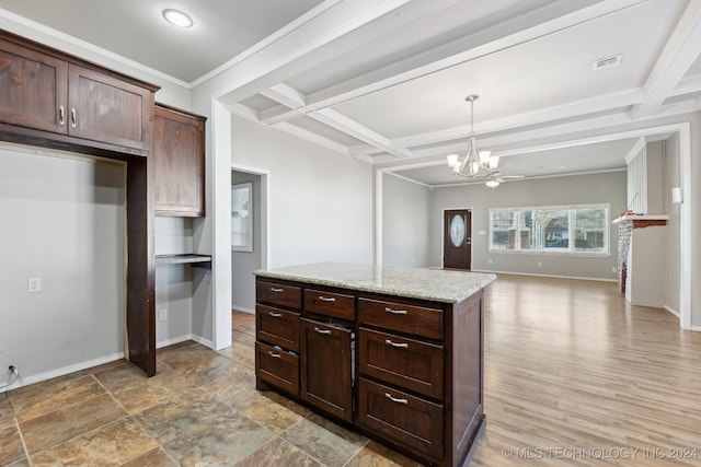 kitchen with decorative light fixtures, coffered ceiling, light stone counters, dark brown cabinets, and an inviting chandelier