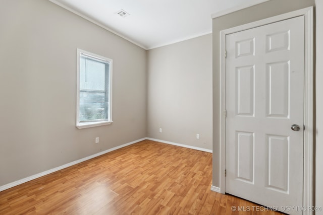 unfurnished room featuring crown molding and light wood-type flooring