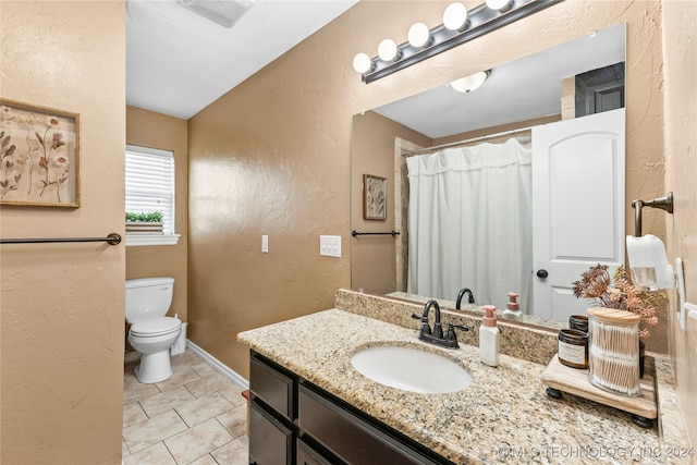 bathroom featuring toilet, vanity, and tile patterned floors