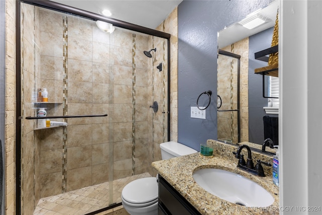 bathroom featuring vanity, toilet, and a shower with door