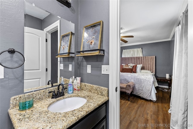 bathroom featuring hardwood / wood-style floors, vanity, ceiling fan, and crown molding