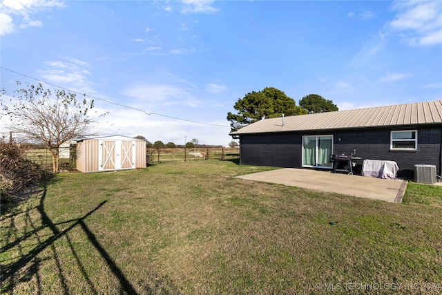 view of yard featuring central AC, a patio, and a shed