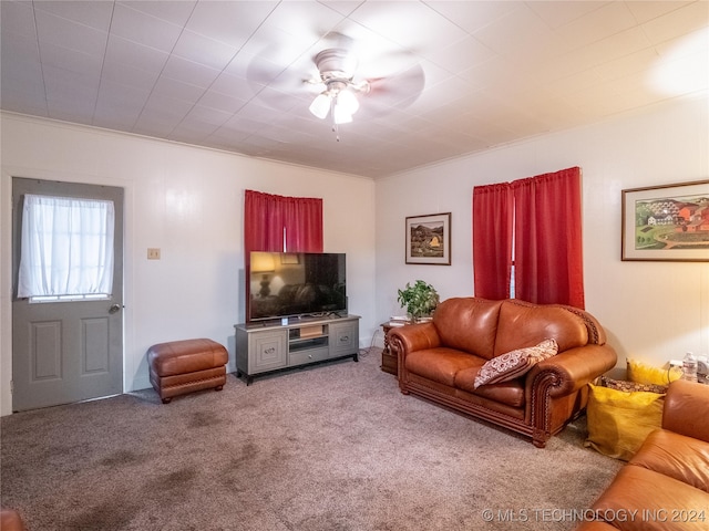 carpeted living room featuring ceiling fan and crown molding