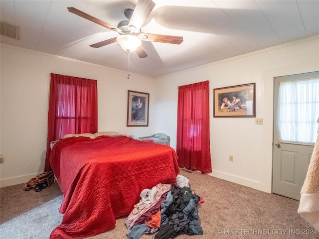 bedroom featuring ceiling fan, crown molding, and carpet floors