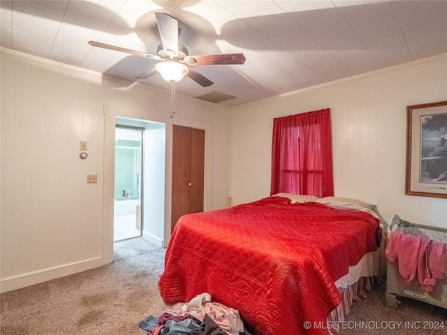 carpeted bedroom featuring ceiling fan and ornamental molding