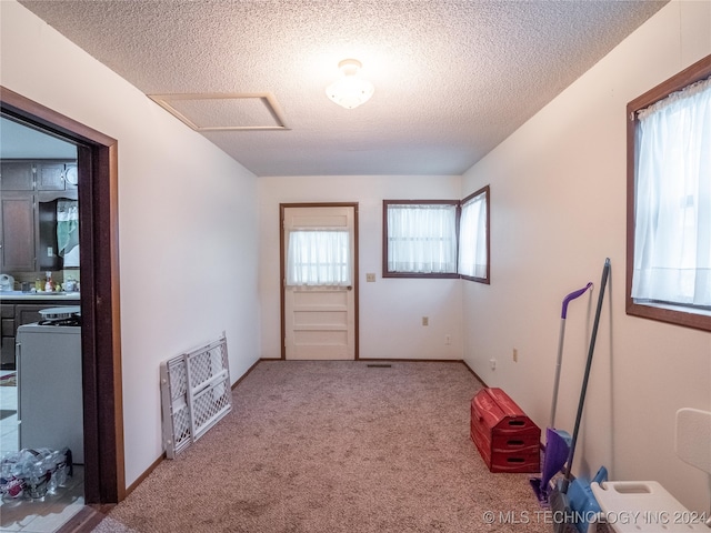 carpeted spare room with a textured ceiling