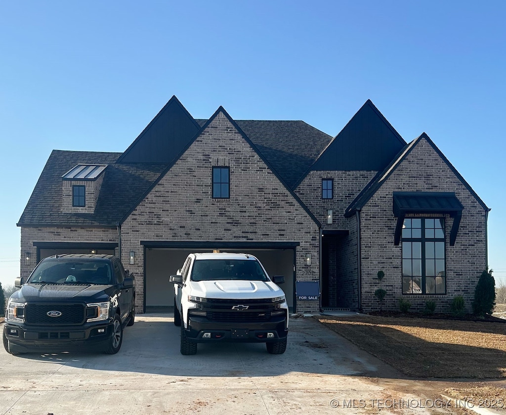 view of front of house featuring a garage, brick siding, and driveway