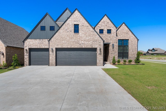3908 S Elder Blvd, Broken Arrow, OK 74012 - view of front of house with board and batten siding, a front lawn, driveway, brick siding, and a garage