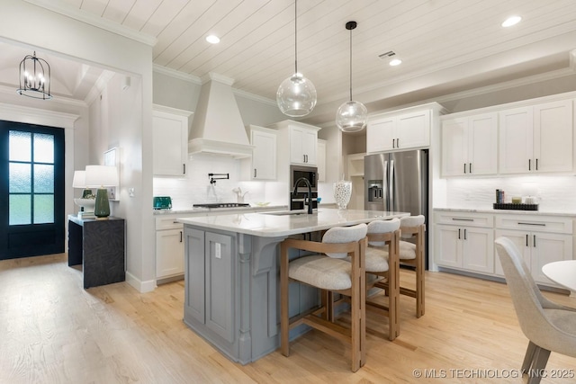 3908 S Elder Blvd, Broken Arrow, OK 74012 - kitchen featuring custom range hood, light wood-type flooring, backsplash, white cabinetry, and crown molding