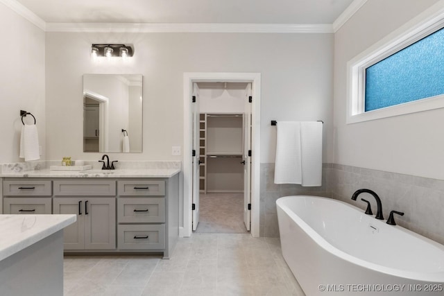 3908 S Elder Blvd, Broken Arrow, OK 74012 - bathroom with a freestanding tub, vanity, a spacious closet, tile patterned flooring, and crown molding