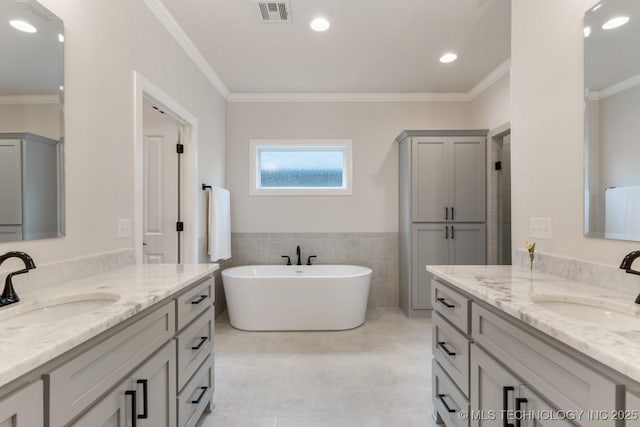 3908 S Elder Blvd, Broken Arrow, OK 74012 - bathroom featuring a soaking tub, ornamental molding, two vanities, tile patterned floors, and tile walls