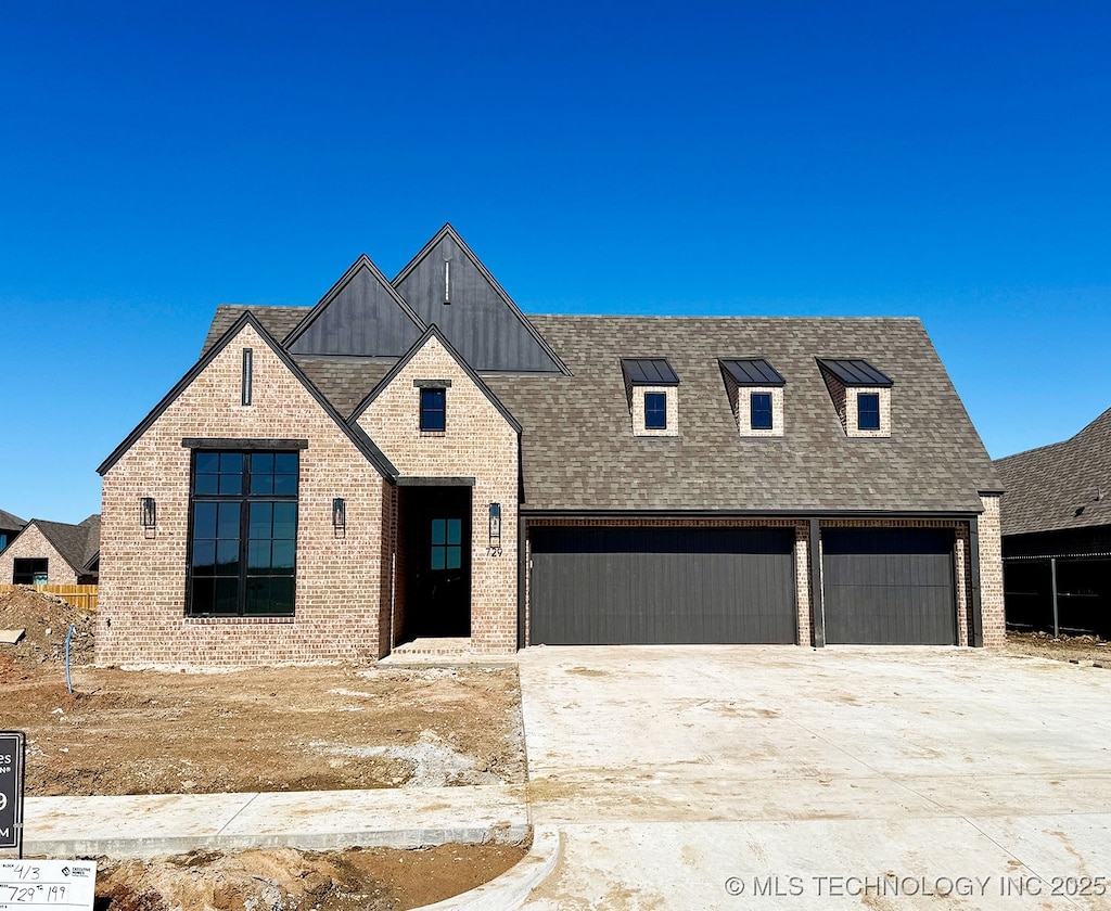 view of front of house featuring an attached garage, concrete driveway, brick siding, and a shingled roof