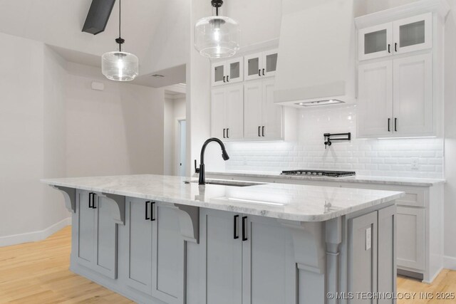 6617 S Fir Ave, Broken Arrow, OK 74134 - kitchen with a sink, premium range hood, baseboards, decorative backsplash, and white cabinets