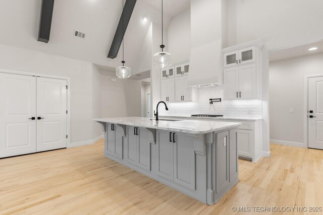 6617 S Fir Ave, Broken Arrow, OK 74134 - kitchen with a sink, high vaulted ceiling, baseboards, a breakfast bar, and white cabinetry
