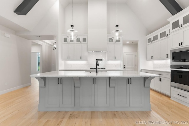 6617 S Fir Ave, Broken Arrow, OK 74134 - kitchen featuring backsplash, high vaulted ceiling, a spacious island, white cabinetry, and light stone counters