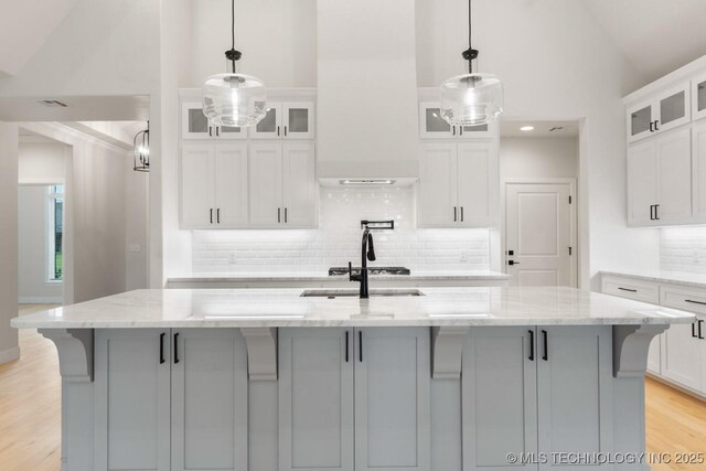 6617 S Fir Ave, Broken Arrow, OK 74134 - kitchen featuring decorative backsplash, light wood finished floors, white cabinetry, and high vaulted ceiling