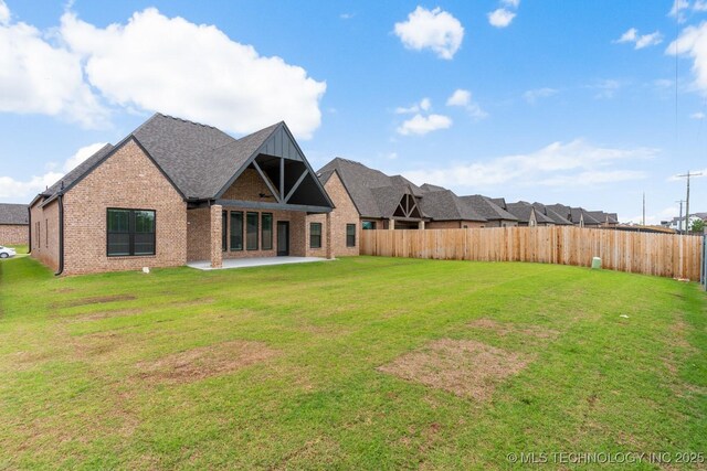 6617 S Fir Ave, Broken Arrow, OK 74134 - back of property featuring brick siding, a patio area, and a shingled roof