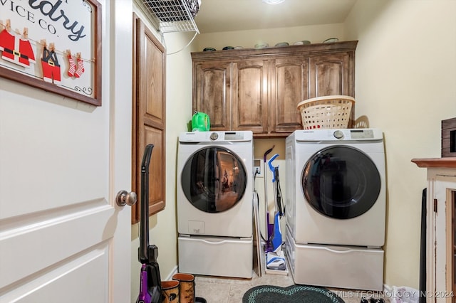 laundry area featuring light tile patterned flooring, cabinets, and washer and dryer