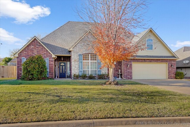 view of front of property featuring a garage and a front lawn