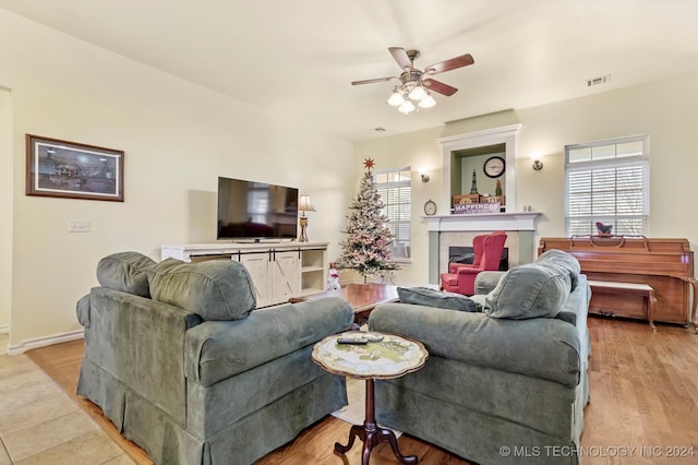 living room with light hardwood / wood-style floors and ceiling fan