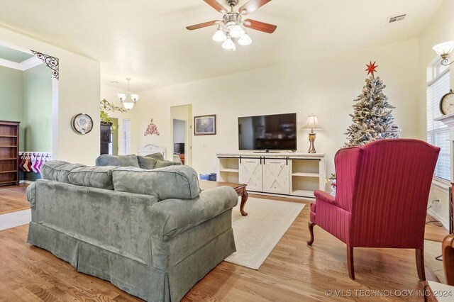 living room featuring ceiling fan with notable chandelier and light hardwood / wood-style floors