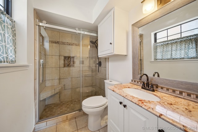 bathroom with tile patterned flooring, toilet, and a shower with door