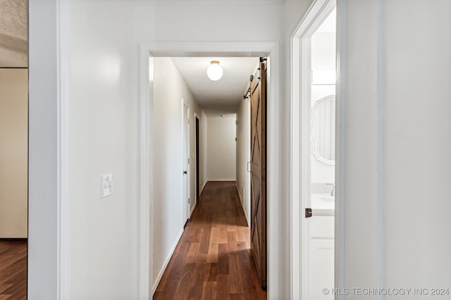 corridor with a textured ceiling and dark hardwood / wood-style flooring