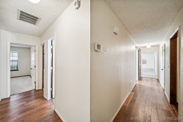 hall featuring hardwood / wood-style floors and a textured ceiling