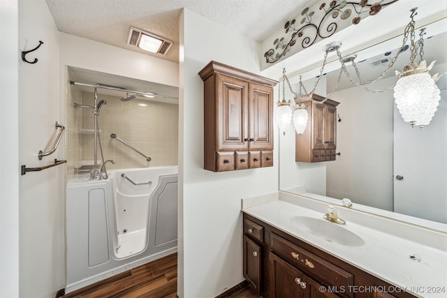 bathroom with wood-type flooring, a textured ceiling, and vanity