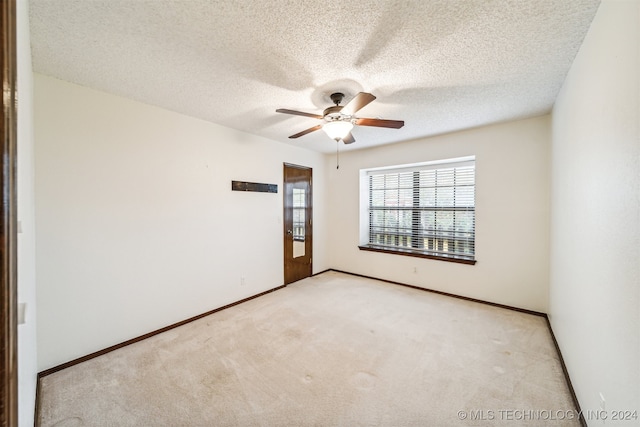 spare room with light carpet, a textured ceiling, and ceiling fan