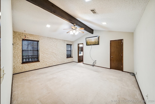 carpeted empty room featuring ceiling fan, a textured ceiling, and lofted ceiling with beams