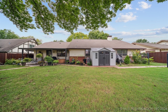 ranch-style home with a front lawn and a storage shed