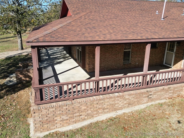 view of side of home featuring covered porch