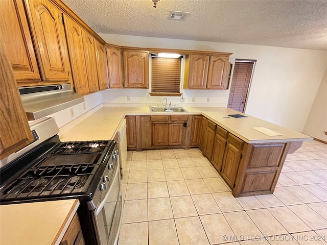 kitchen with light tile patterned flooring, a textured ceiling, sink, and stainless steel gas range