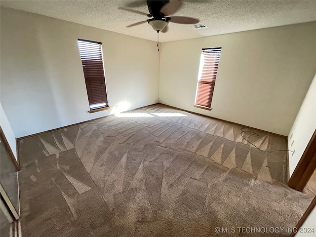 carpeted spare room with ceiling fan and a textured ceiling