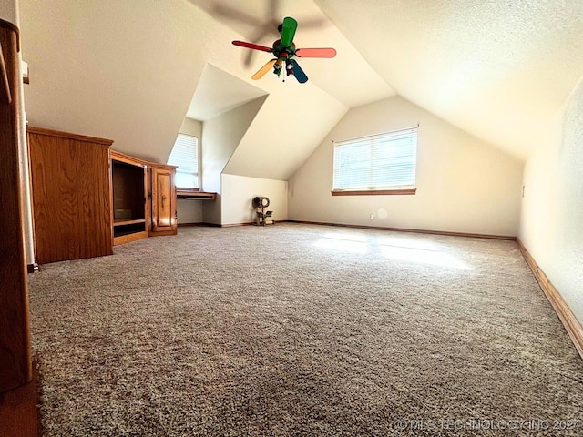 bonus room featuring a textured ceiling, a wealth of natural light, lofted ceiling, and ceiling fan