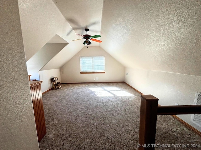 additional living space featuring carpet flooring, a textured ceiling, vaulted ceiling, and ceiling fan