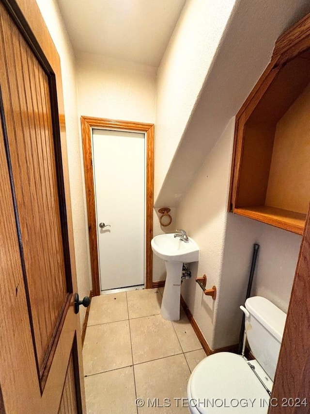 bathroom with tile patterned flooring, toilet, and sink