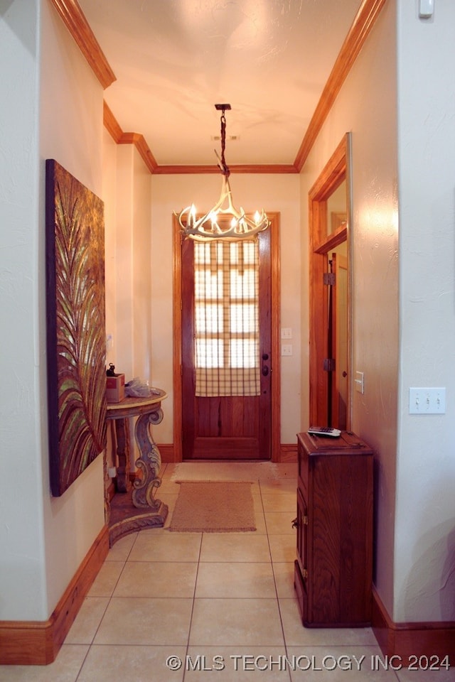 foyer featuring light tile patterned floors, crown molding, and a chandelier