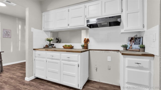 kitchen with butcher block countertops, decorative backsplash, white cabinetry, and dark hardwood / wood-style flooring