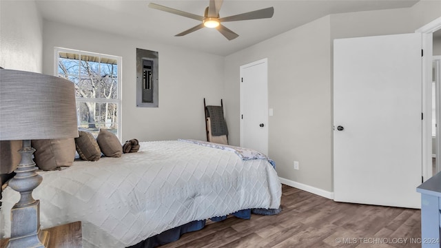 bedroom with electric panel, ceiling fan, and wood-type flooring