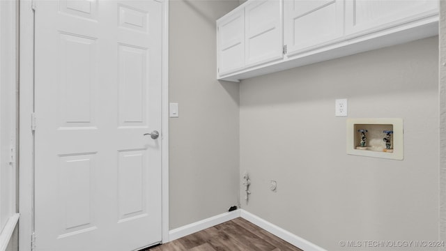 washroom featuring dark hardwood / wood-style flooring, cabinets, and hookup for a washing machine